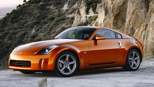 Sunlit orange sports coupe pausing by rugged mountain cliffs.