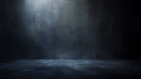 Empty dark studio room with textured concrete wall backdrop.