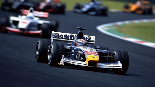 Open-wheel race car leading multi-car pack through fast curve.