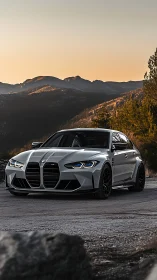 Silver BMW sports sedan parked on mountain roadside at dusk.