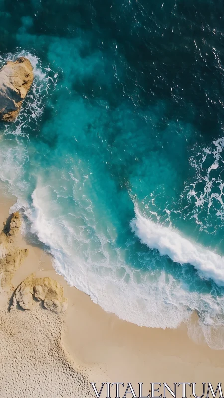 Aerial turquoise surf rolling onto golden sand shoreline.