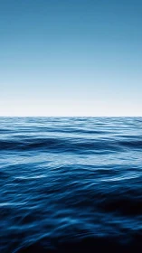 Endless blue ocean waves meeting a soft, peaceful sky.