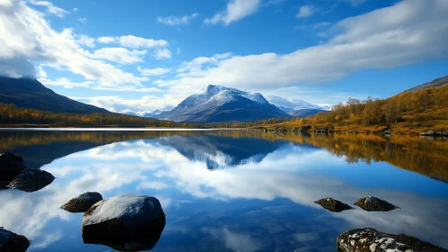 Symmetric alpine lake reflection with snowcapped massif focus.
