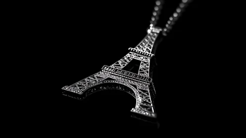 Macro close up isolates jeweled Eiffel Tower pendant in noir light