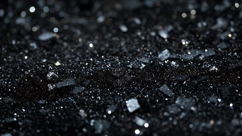 Black glitter surface with metallic shard bokeh lights.