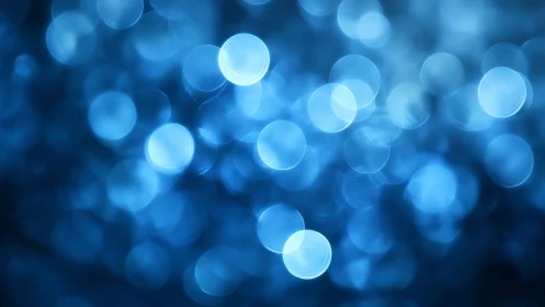 Abstract blue bokeh lights background with soft blurred circles.