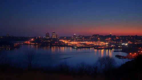 Evening city shoreline glows gently against deep blue sky