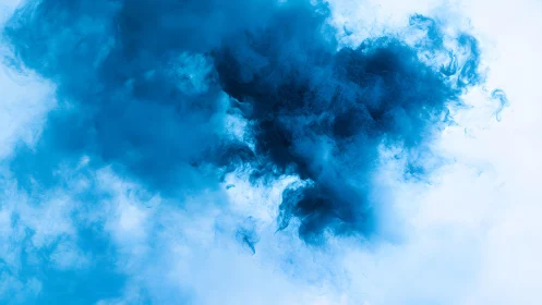 Abstract swirling blue ink cloud in water on white background.
