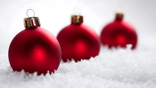 Macro closeup of red matte baubles on textured snow field