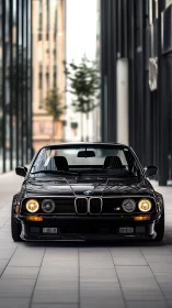 Classic black sports sedan aligned in modern city corridor.