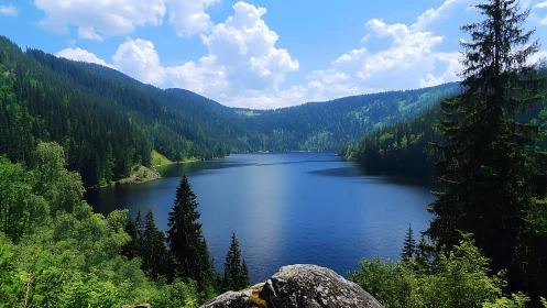 Mountain lake panorama under vibrant midday sky.
