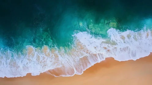 Aerial turquoise breakers washing over smooth sand shoreline.