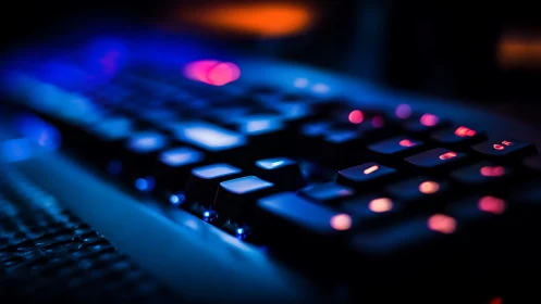 Close-up of illuminated keyboard with blue and pink lighting.
