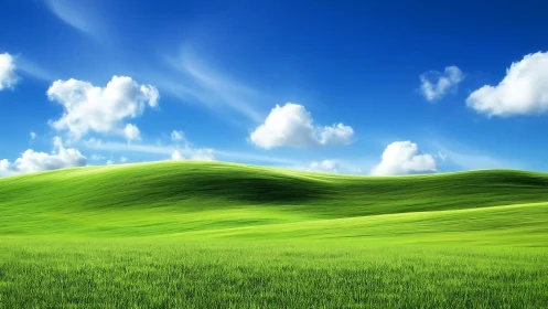 Luminous green hillside under deep blue sky with clouds.