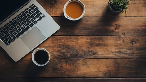 Overhead workspace with laptop, dual coffee cups, rustic wood