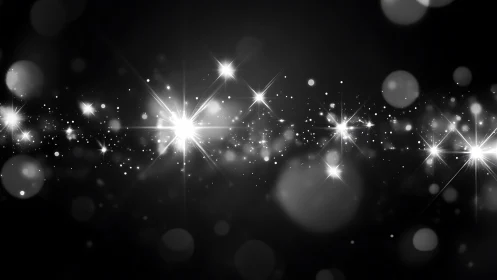 Bright white light flares on dark background in soft focus.