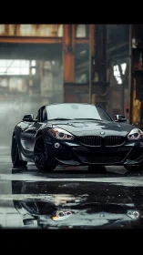 Matte black BMW roadster stands in rain-soaked industrial hangar