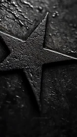 Textured black metal star emerges from dark surface.