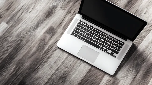 Quiet laptop on sunlit wooden floor, inviting fresh starts.