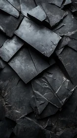 Layered slate shards form interlocking dark geometric fracture planes