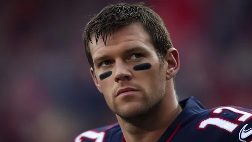 Focused football player in navy jersey, calm and ready.