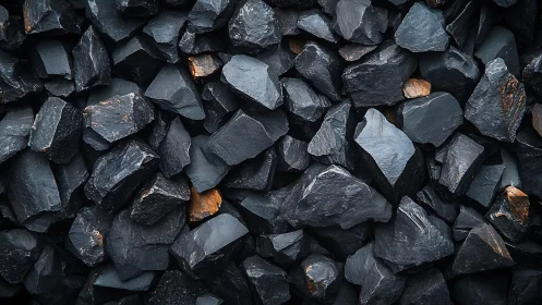 Coal stones in tight textured pile with subtle orange flecks.