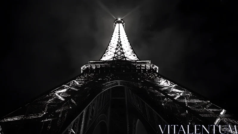 Illuminated Eiffel Tower structure viewed from below at night.