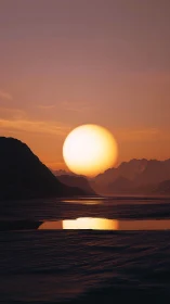 Low-angle sun over stratified mountains with reflective water plane