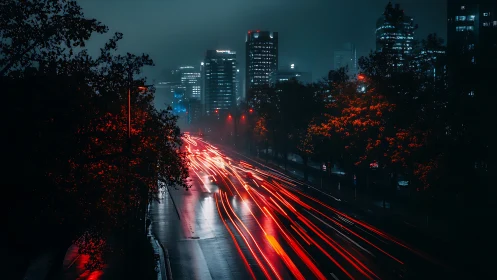 Night city highway with red light trails and tall buildings.