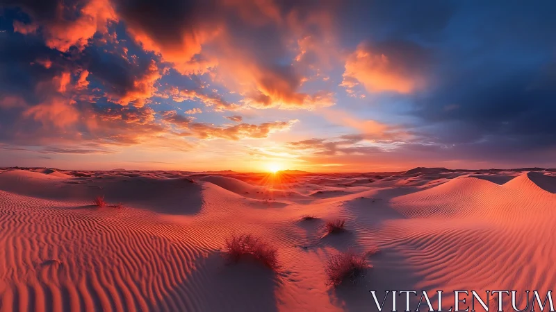 Sunset illuminates rippled desert dunes under dramatic clouds