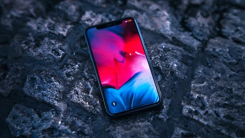 Smartphone with gradient display on dark textured surface