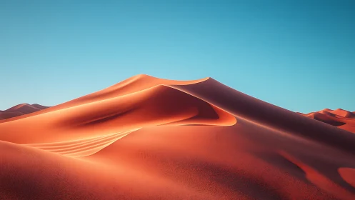 Sunlit desert dunes curling beneath a clear blue sky.