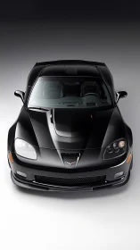 Black performance coupe in dramatic studio top view.