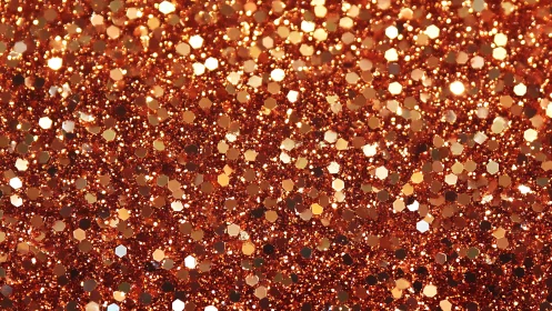 Copper-toned hexagonal glitter particles in close view.