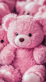 Close view of pink plush teddy bear among similar toys.