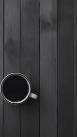 White mug of black coffee on dark vertical wooden planks.