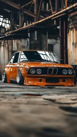 Lowered orange BMW classic in abandoned industrial hall.