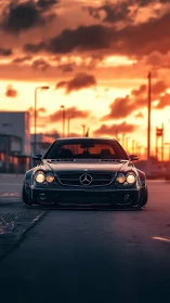Lowered black Mercedes coupe parked on street at sunset