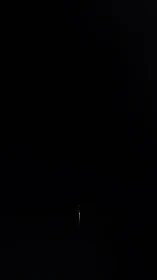 Solitary needle of light threading silence through blackness.