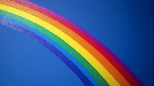 Vibrant arc rainbow against deep blue sky backdrop.