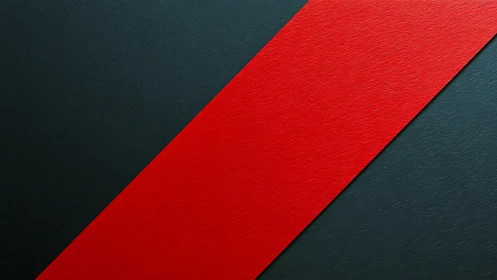 Diagonal red stripe on textured dark graphite surface.