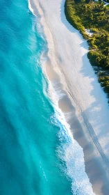 Aerial view of tropical beach with turquoise water and white sand strip.