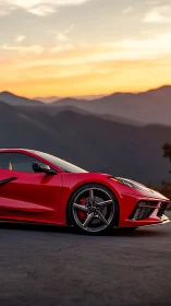 Red mid‑engine sports coupe at dusk on mountain overlook