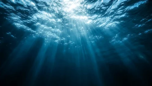 Sunlight pierces deep blue ocean water in tranquil silence