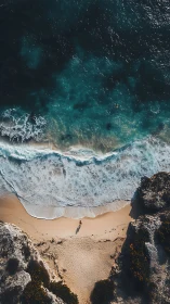Solitary shoreline wanderer beneath teal thunder surf.