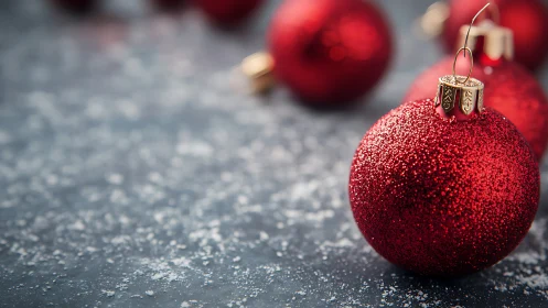 Glistening red baubles resting on a frosted winter table.