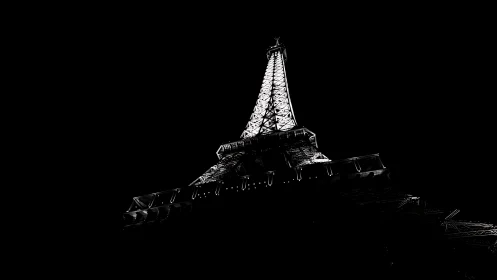 Eiffel Tower illuminated at night in stark black background.