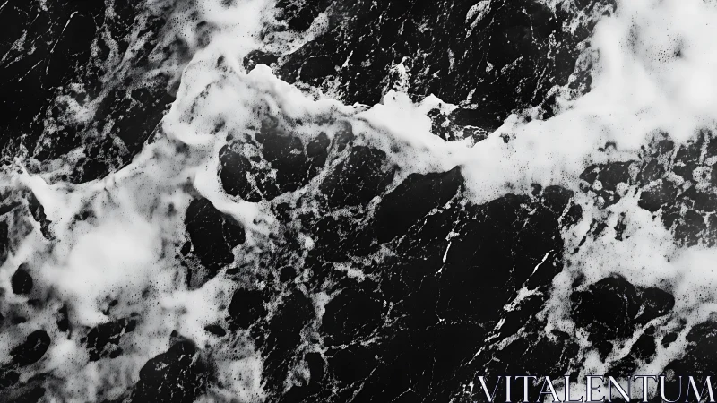 Monochrome aerial view of ocean surface with foam patterns.