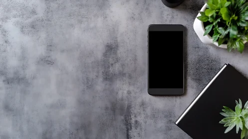 Modern Workspace: Smartphone and Greenery on Concrete