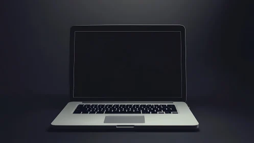 Closed laptop with dark screen on black studio background.